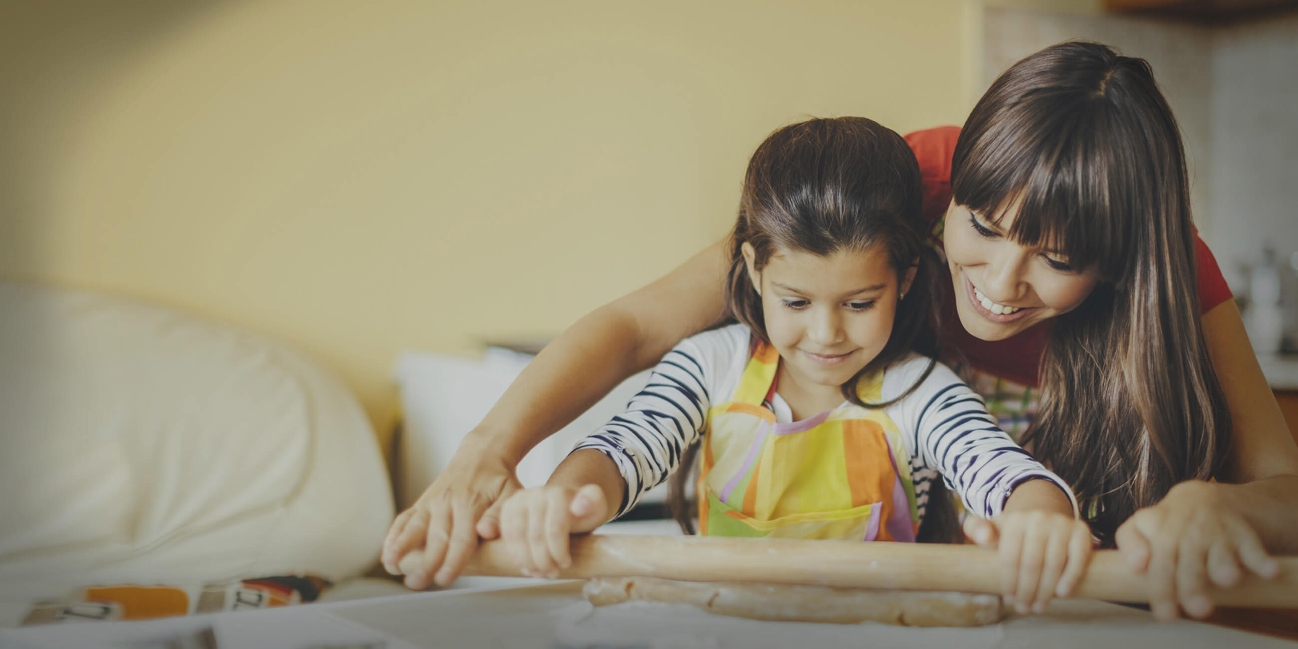 mother and daught rolling out dough